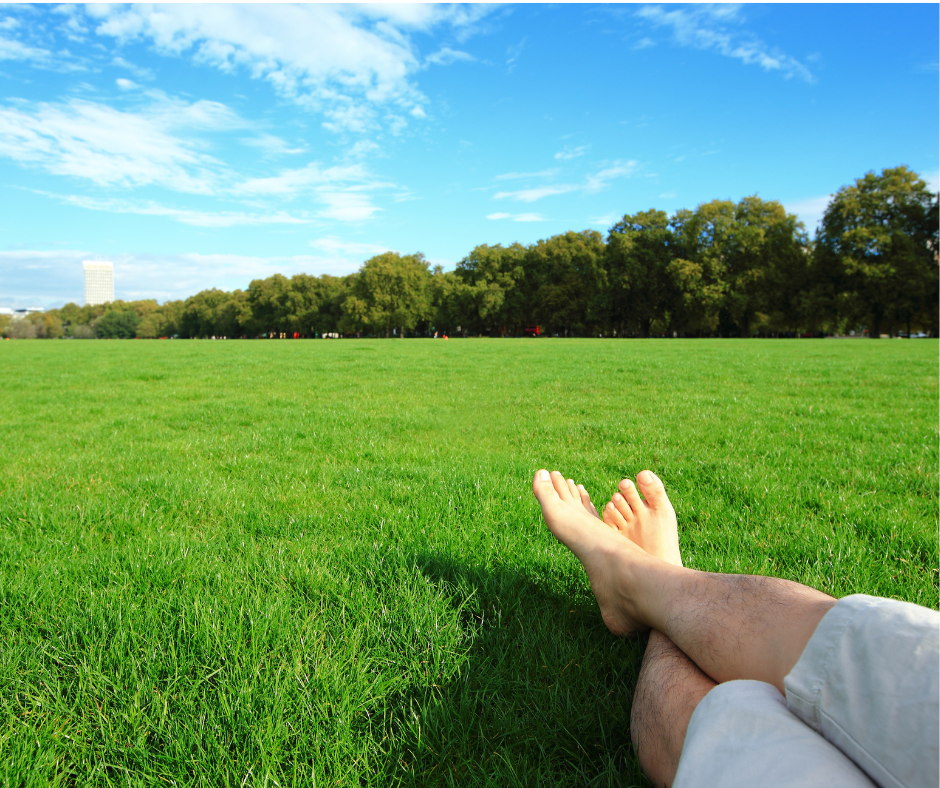 A woman barefoot in grass enjoying a peaceful summer morning.