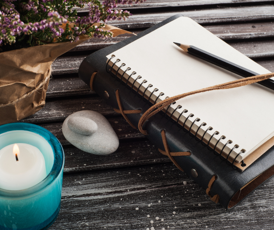 A journal and pen resting on a wooden table, inviting quiet reflection.